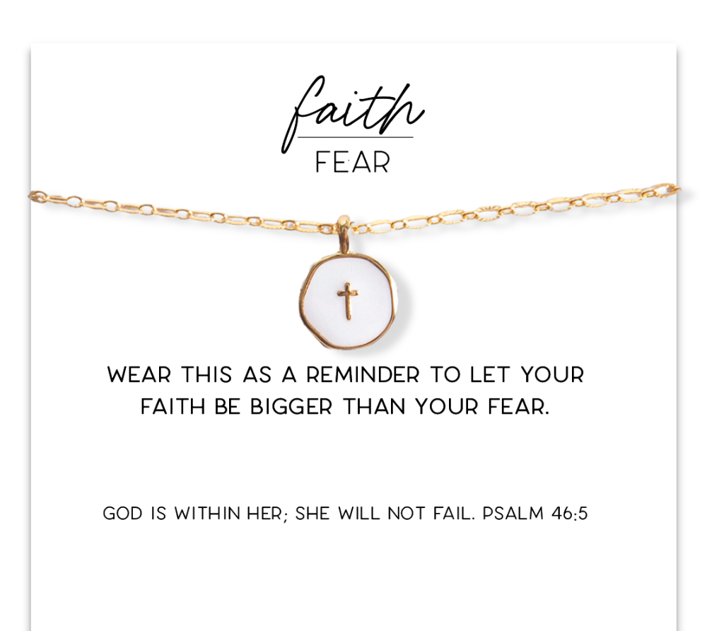 Gold necklace with a cross pendant on a white card with text and branding.