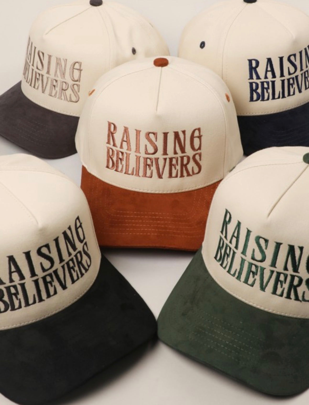 Collection of hats with 'Raising Believers' text on a white background
