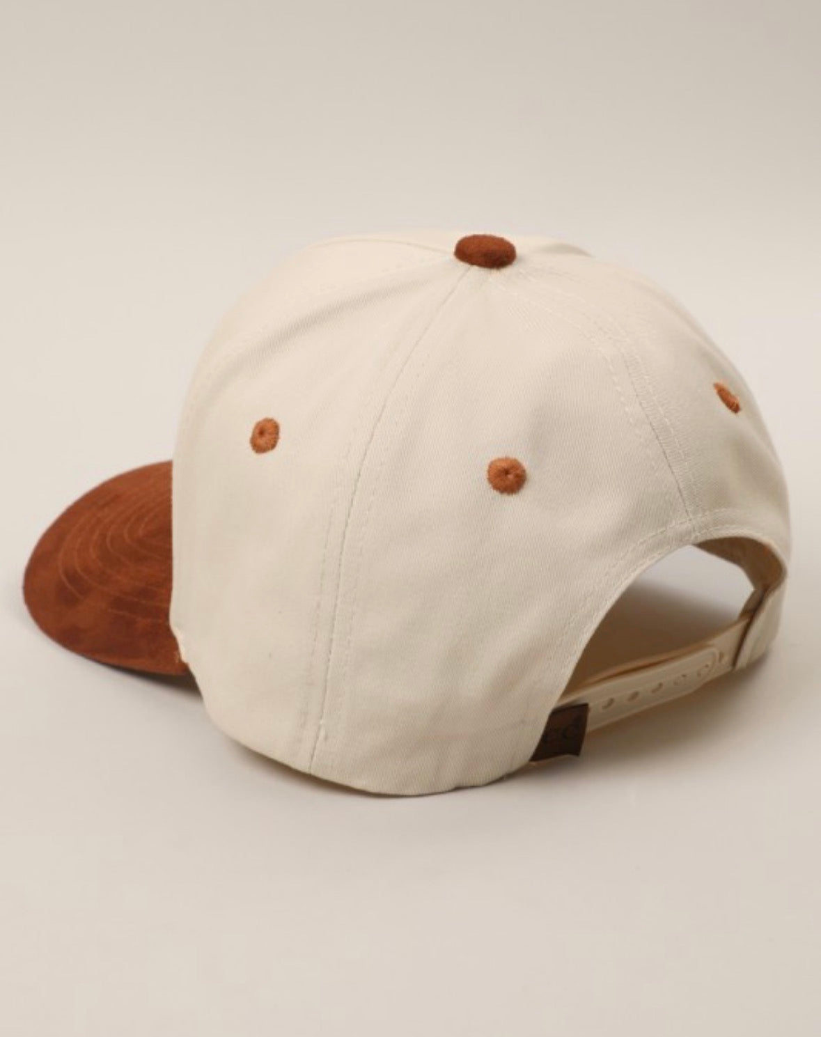 Beige cap with brown accents on a light beige background