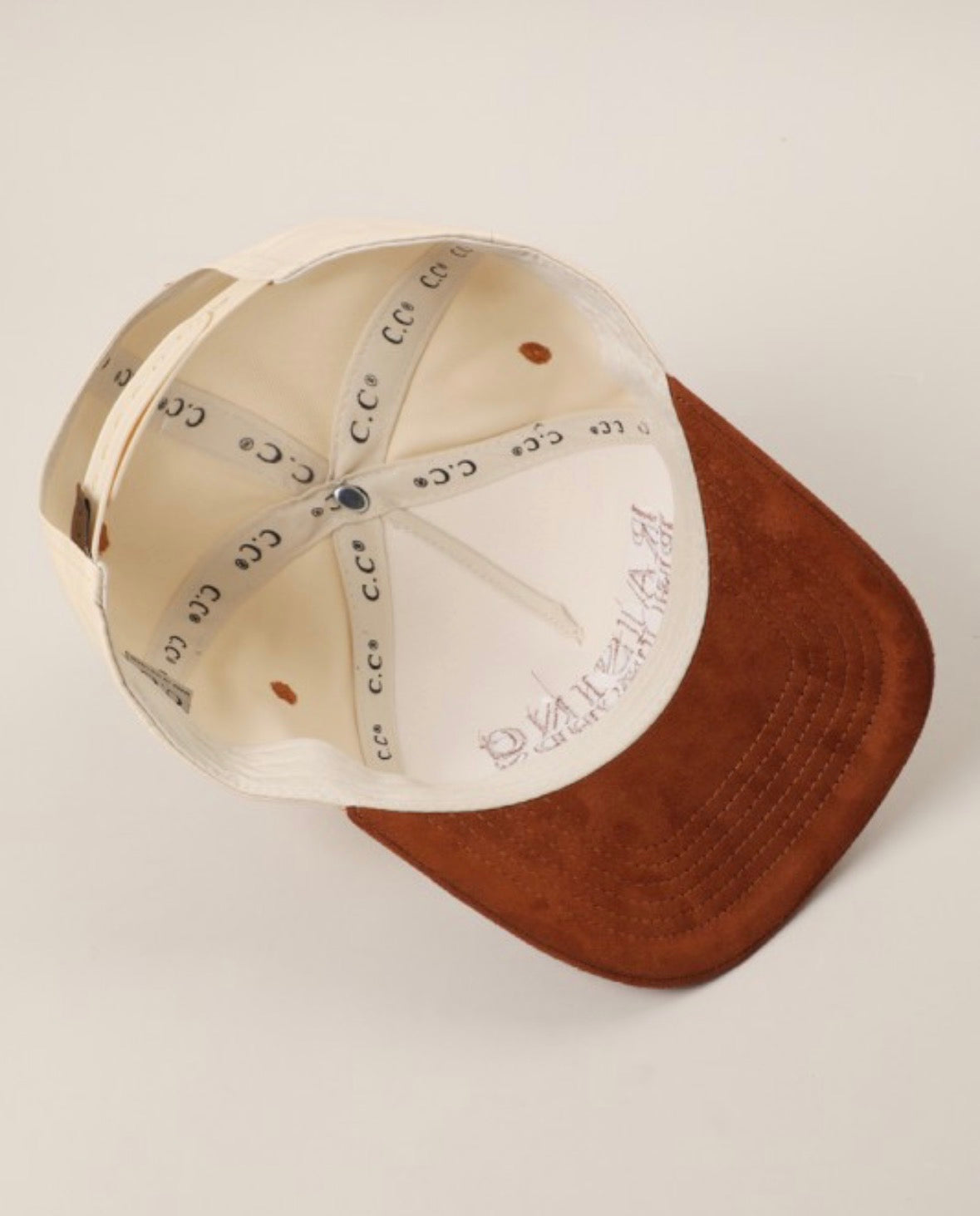 Two baseball caps, one beige and one brown, on a light gray background.