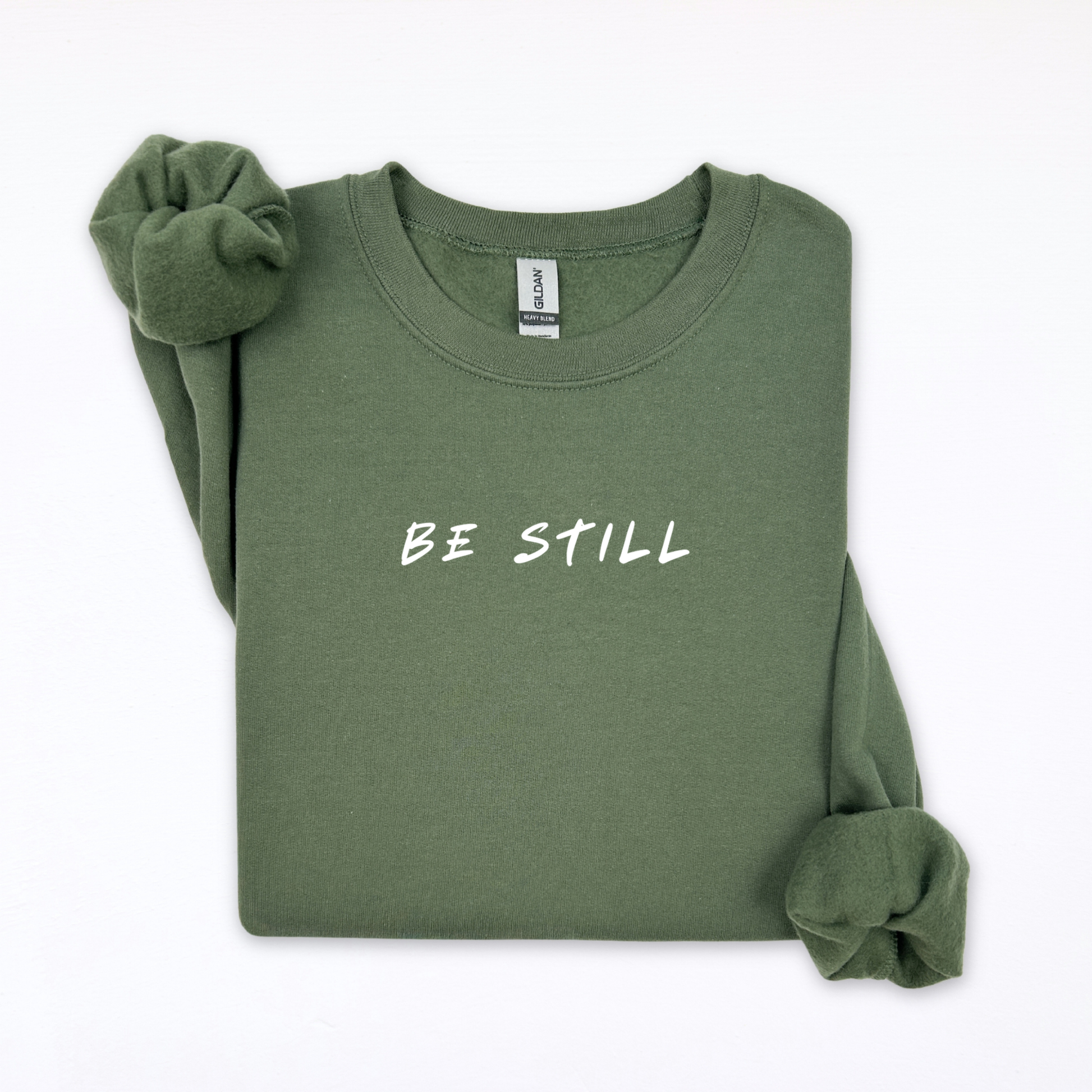 Green sweatshirt with 'BE STILL' text on a white background